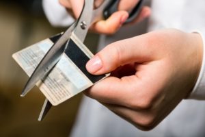 man cutting credit card