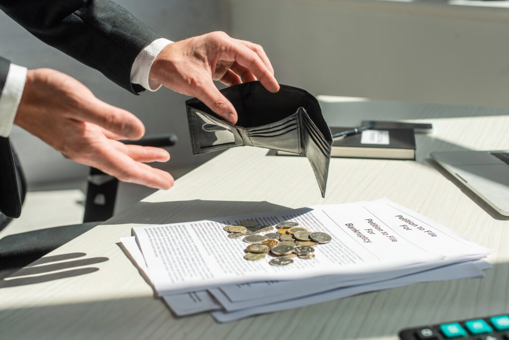 Cropped-view-of-businessman-holding-empty-wallet-near-coins