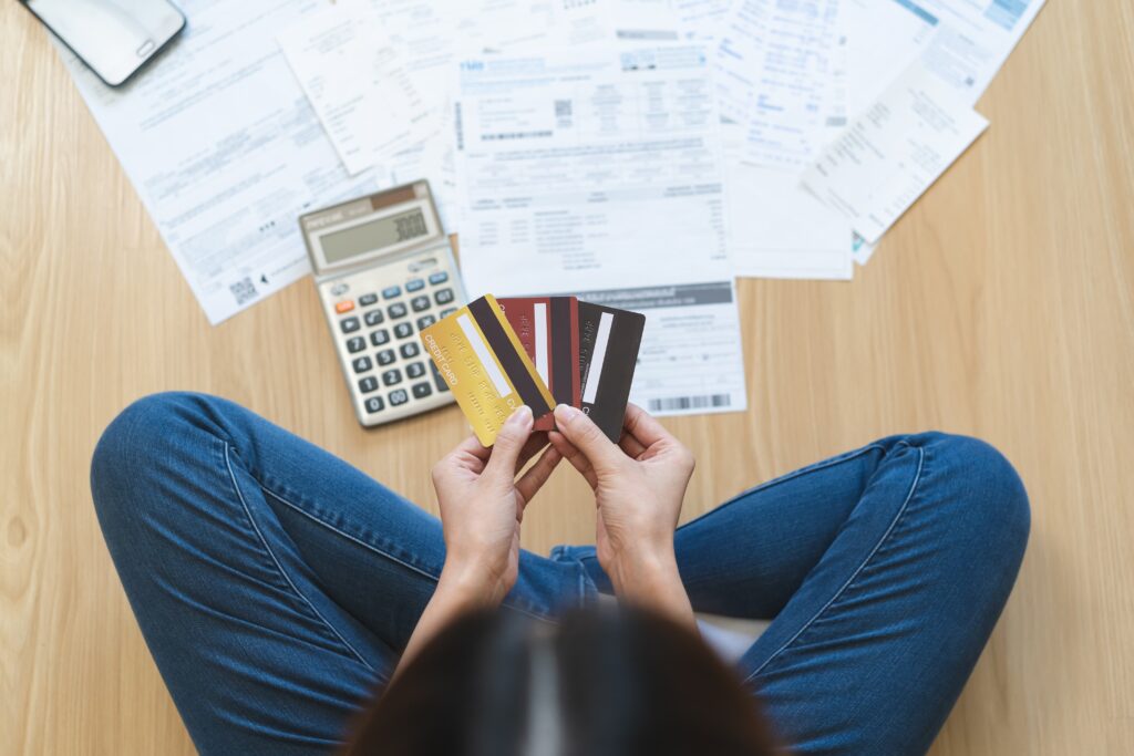 Top view of stressed young woman trying to find money to pay credit card debt.